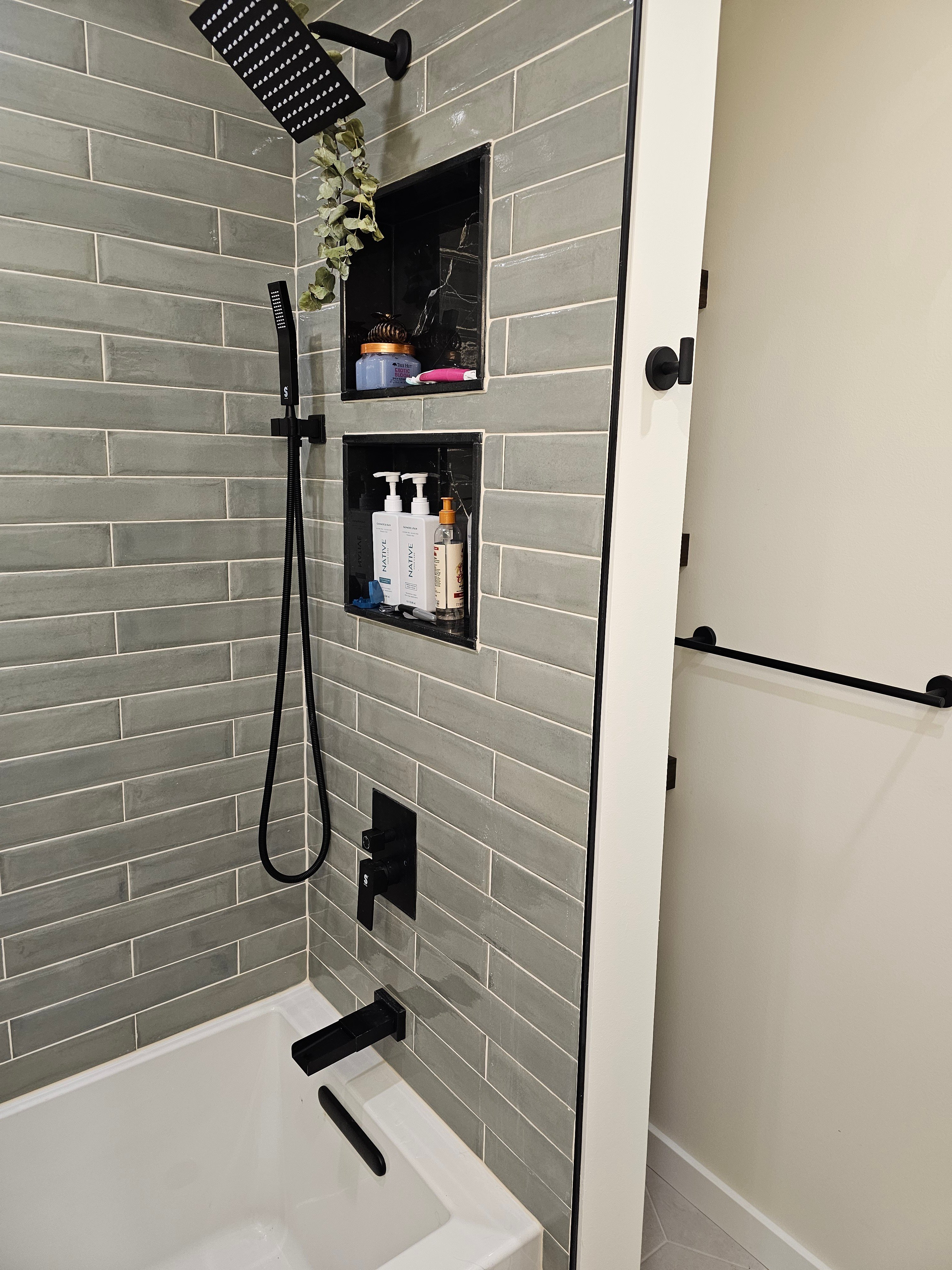 Shower with grey tile and black fixtures