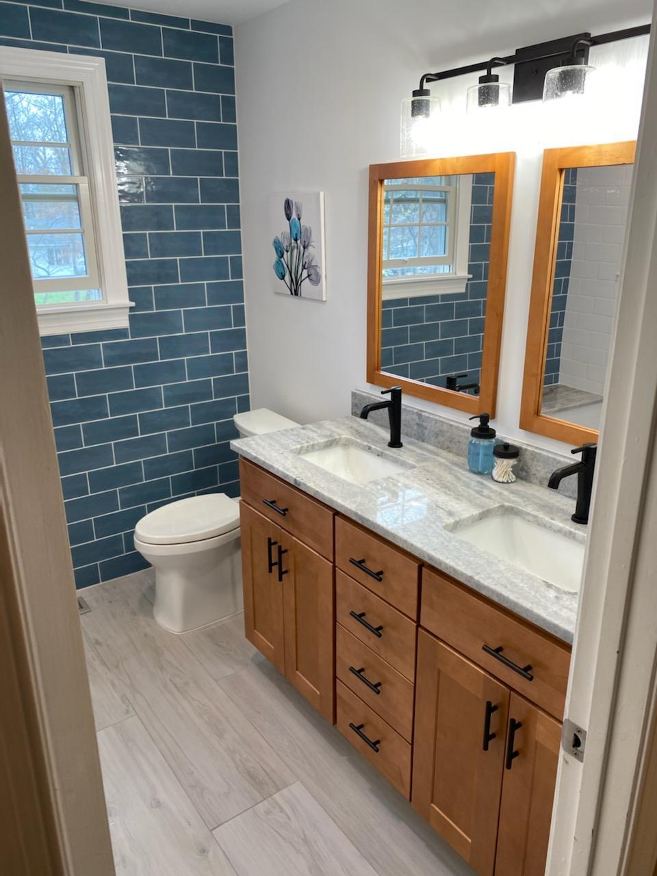 Bathroom with blue tiles and wood cabinet finish